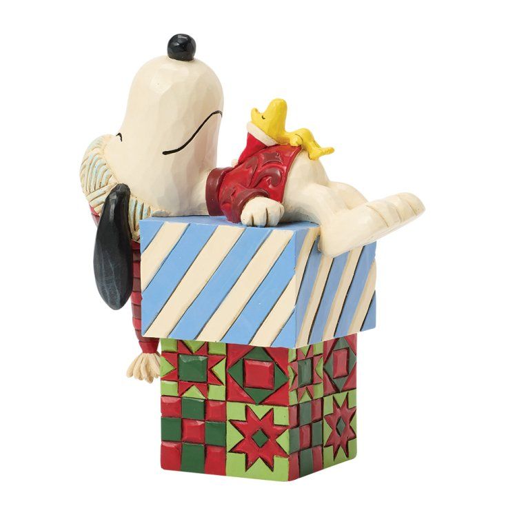 Snoopy en Woodstock op een stapel kleurrijk versierde blokken. Snoopy slaapt, Woodstock rust uit.