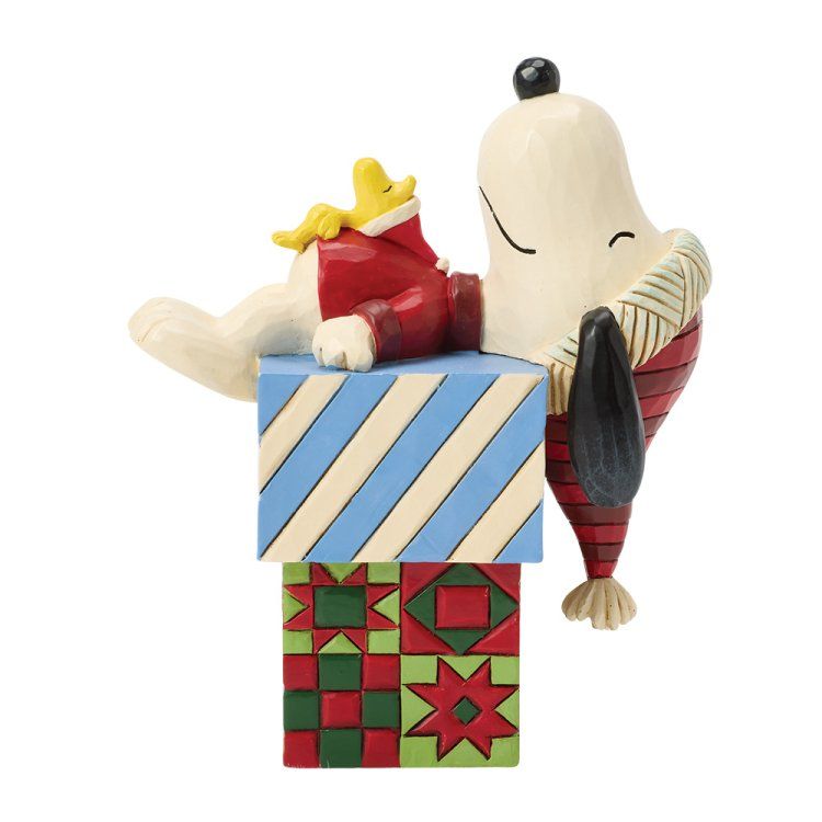 Snoopy-figuurtje met Woodstock, leunend op cadeaudozen; blauw/witte strepen, rode en groene sterrenpatronen.