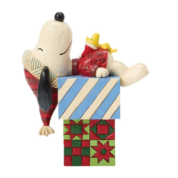 Snoopy en Woodstock op een stapel kleurrijk versierde blokken. Snoopy slaapt, Woodstock rust uit.
