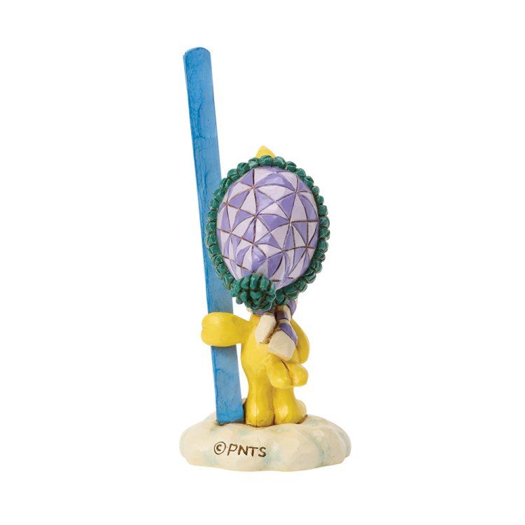 Een gele figuur in winterkleding, die een blauwe skistok vasthoudt, staat op een sneeuwondergrond met een ballon met geometrisch patroon.
