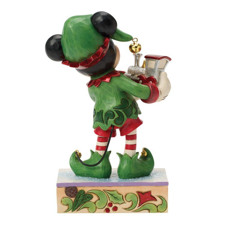 Een muisje met elfenoren in een groen pakje houdt een miniatuurtreintje vast. Rode en groene accenten; besneeuwde achtergrond.