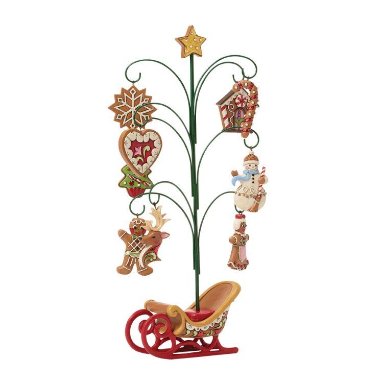 Een kerstboom met peperkoekversieringen en een slee als voetstuk.