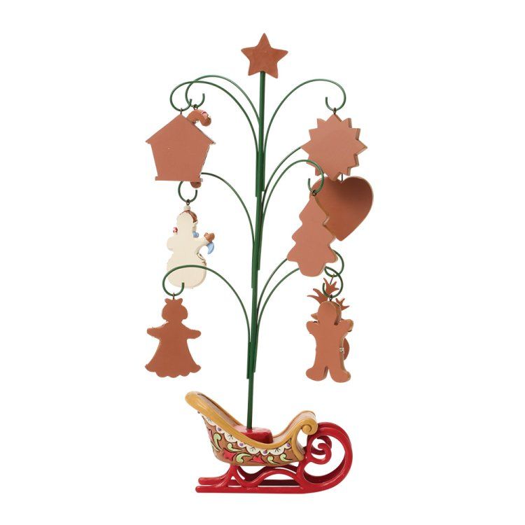 Metalen kerstboomversiering met ornamenten, op een rode sleevoet.