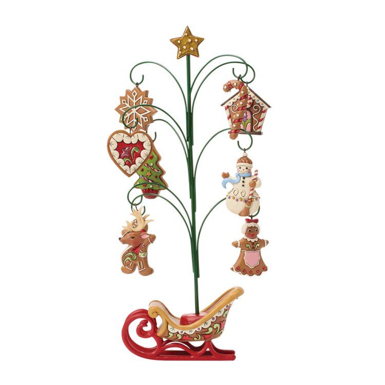 Een kerstboom met peperkoekversieringen en een slee als voetstuk.