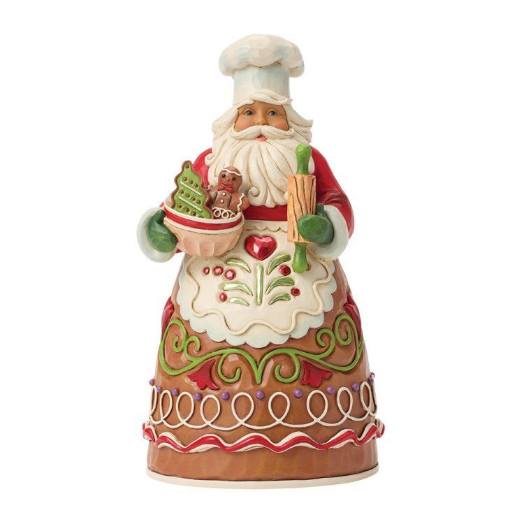 De kerstman, met koksmuts en schort aan, houdt een cupcake en een deegroller vast, versierd in peperkoekstijl.