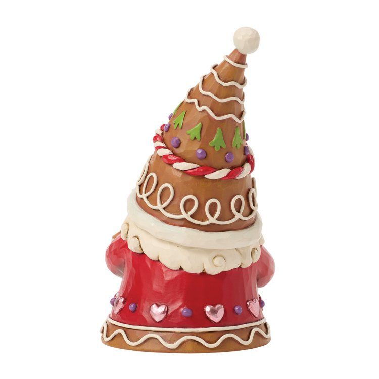 Peperkoekkabouterfiguurtje, rode jas, bruine hoed, feestelijke versieringen.