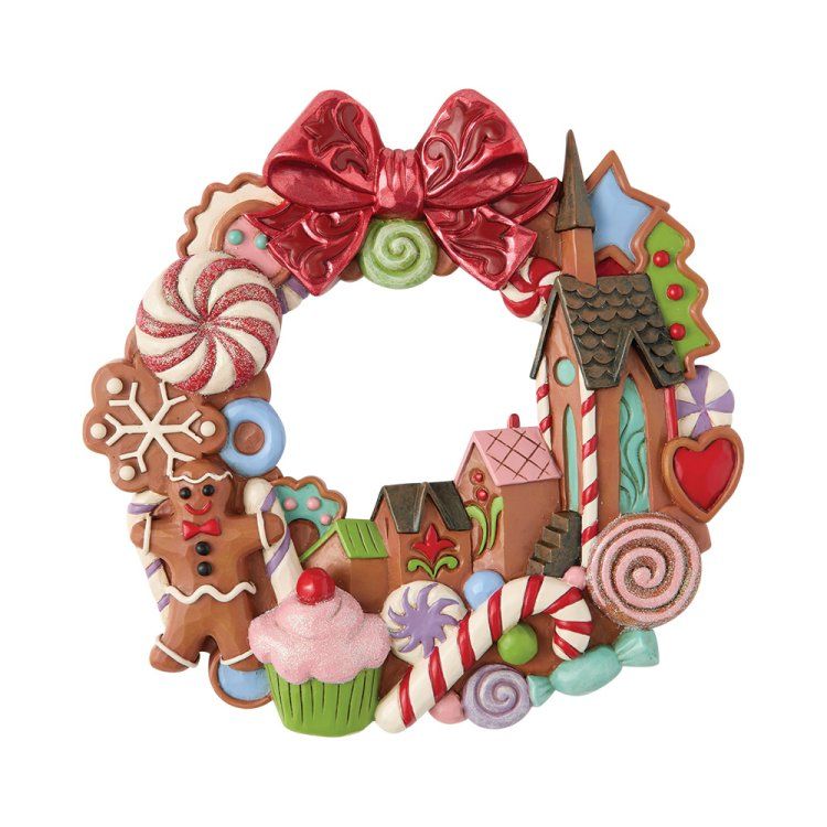 Een feestelijke krans met peperkoekthema, versierd met een strik, koekjes en snoep.