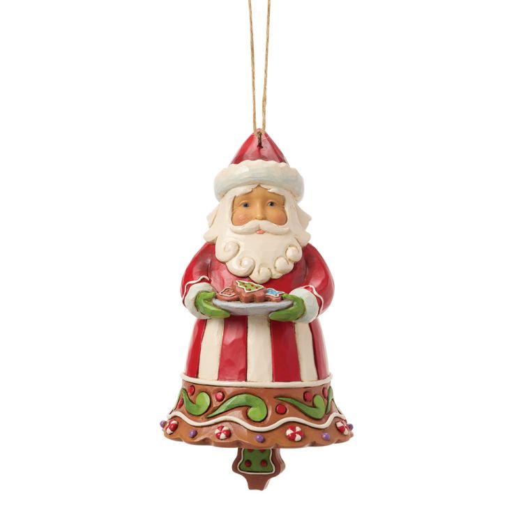 Een kerstornament van de Kerstman met een bord koekjes in zijn hand, gekleed in een rood-wit gestreept pak.