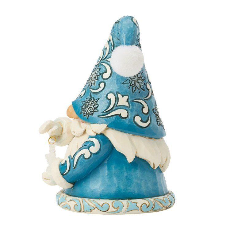 Een blauw kabouterfiguurtje dat een sneeuwvlok vasthoudt, een hoed en jas met sneeuwvlokversiering draagt ​​en een witte baard heeft.