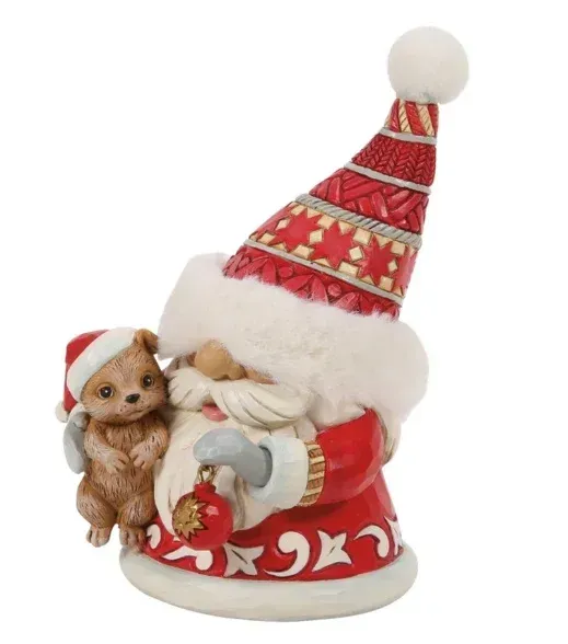 Een kerstmanfiguur met een klein diertje, die een kerstbal vasthoudt. In rode en witte kleuren.