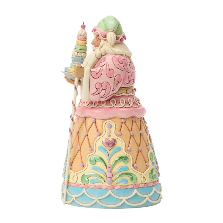 Een kleurrijk kerstmanfiguurtje in pastelkleuren, met een kaars in de vorm van een kerstboom.