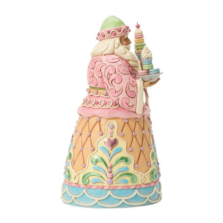 Een kleurrijk kerstmanfiguurtje met een stapel brandende kaarsen. In pastelroze, groen, geel en blauw.