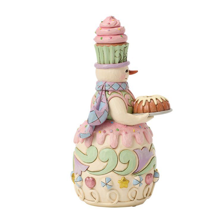 Sneeuwpopfiguurtje met gestapelde cupcakes, die een taart vasthoudt, versierd in pastelkleuren.