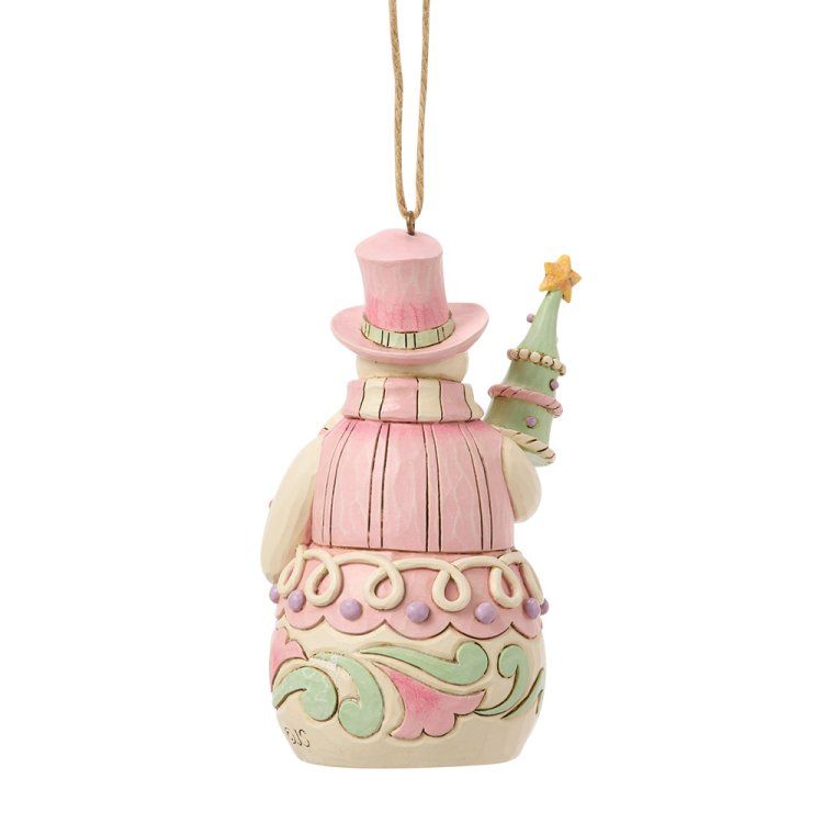 Een sneeuwpop als ornament, met een roze hoge hoed en vest, die een klein kerstboompje vasthoudt, en een beige touwtje om hem op te hangen.