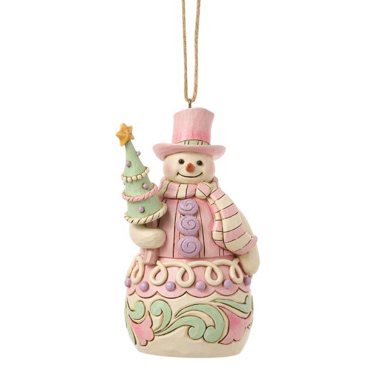 Een sneeuwpop als kerstversiering met een roze jas, muts en sjaal, die een groene kerstboom met een gouden ster vasthoudt.