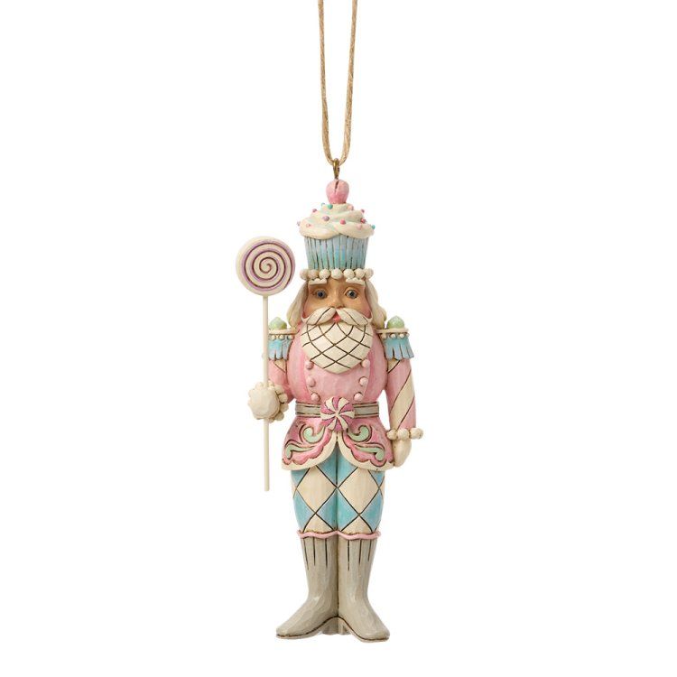 Een roze en blauwe notenkraker-ornament met een lolly in zijn hand en een cupcake-hoedje op.