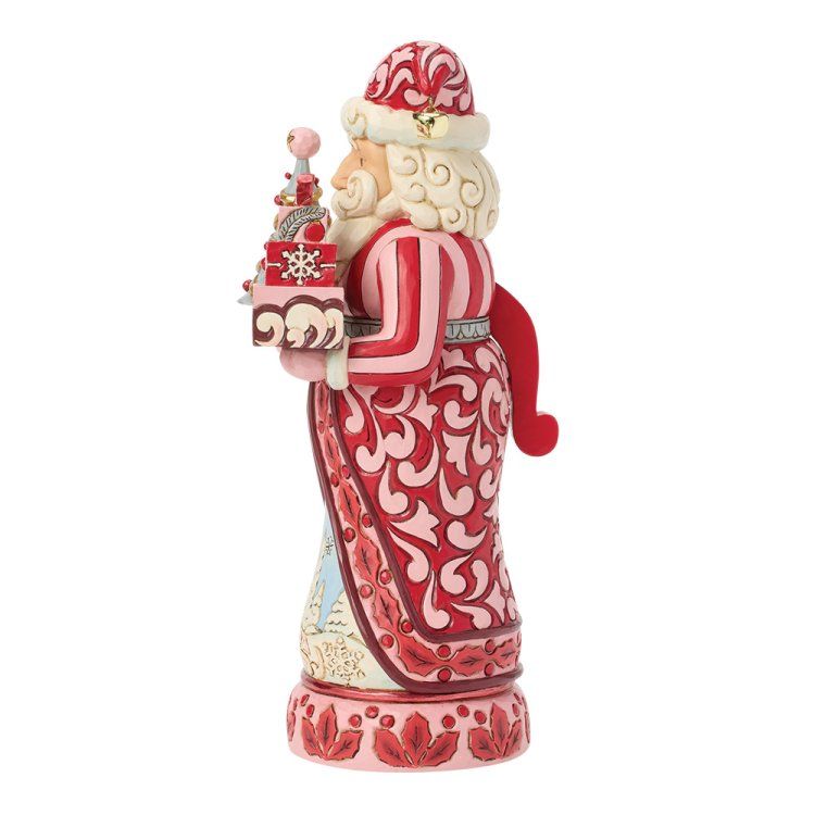 Feestelijk kerstmanfiguurtje met een rood patroonkleed, dat een versierde toren vasthoudt en een kerstmuts draagt.