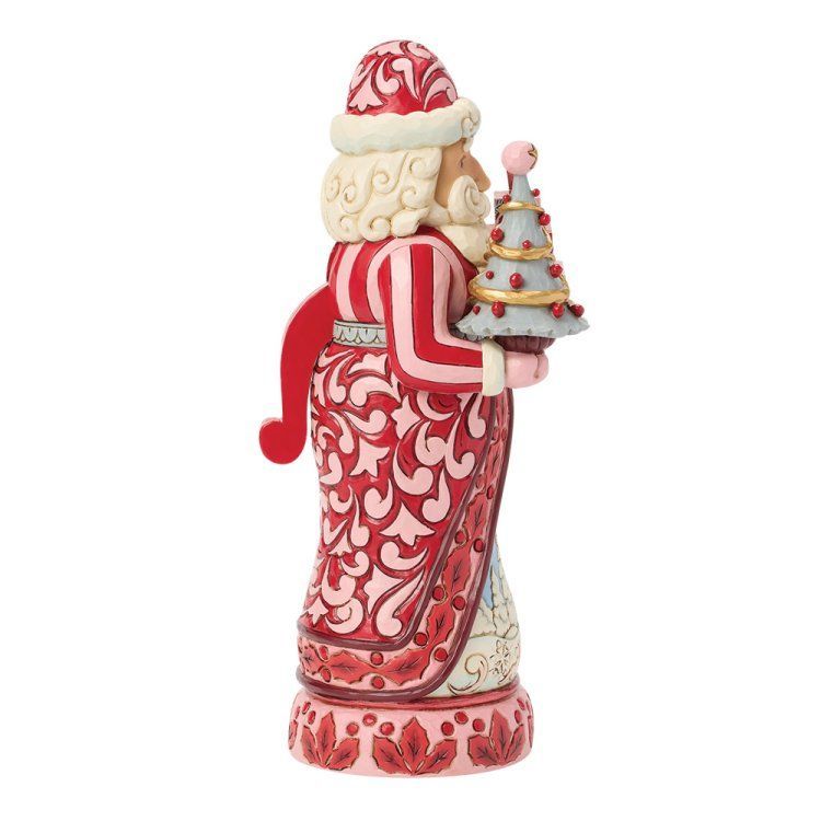 Figuurtje van de kerstman in een rood-roze gewaad, met een kleine kerstboom in zijn handen.