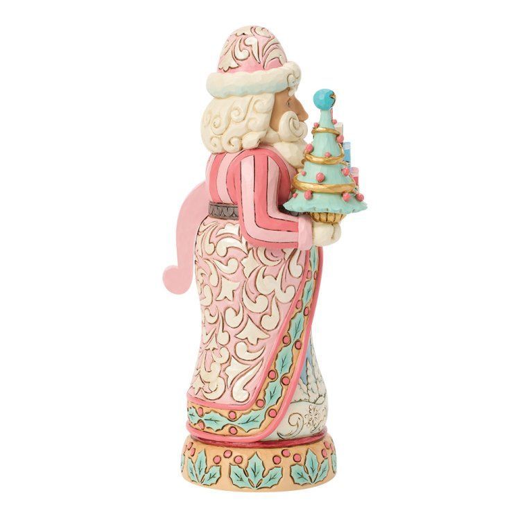 Een decoratieve kerstmanfiguur met een klein kerstboompje. In de kleuren roze, wit en turquoise.