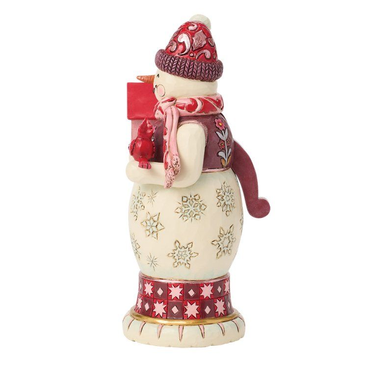 Sneeuwpopfiguurtje met rode muts, sjaal en vogelhuisje, versierd met bloemenpatronen.