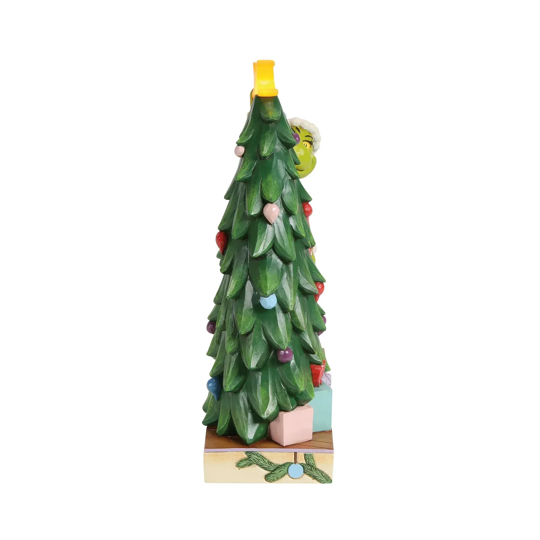 Een verlichte kerstboom met versieringen, cadeautjes en een ster bovenop.
