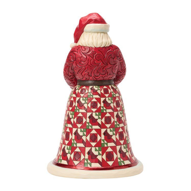 Een kerstmanfiguur met een vogelnest vol rode vogels; gekleed in een rood-groen patroonmantel.