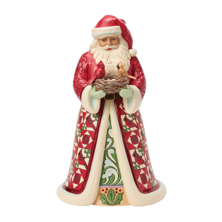 Een kerstmanfiguur met een vogelnest vol rode vogels; gekleed in een rood-groen patroonmantel.