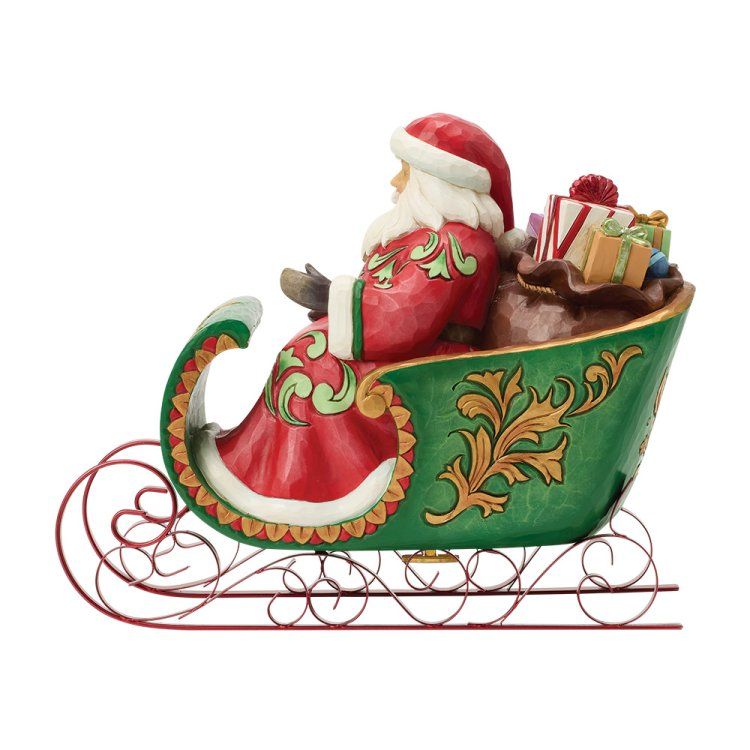 De kerstman, gekleed in een rode jas en muts, zit in een groene slee vol cadeaus, op een rode metalen rail.