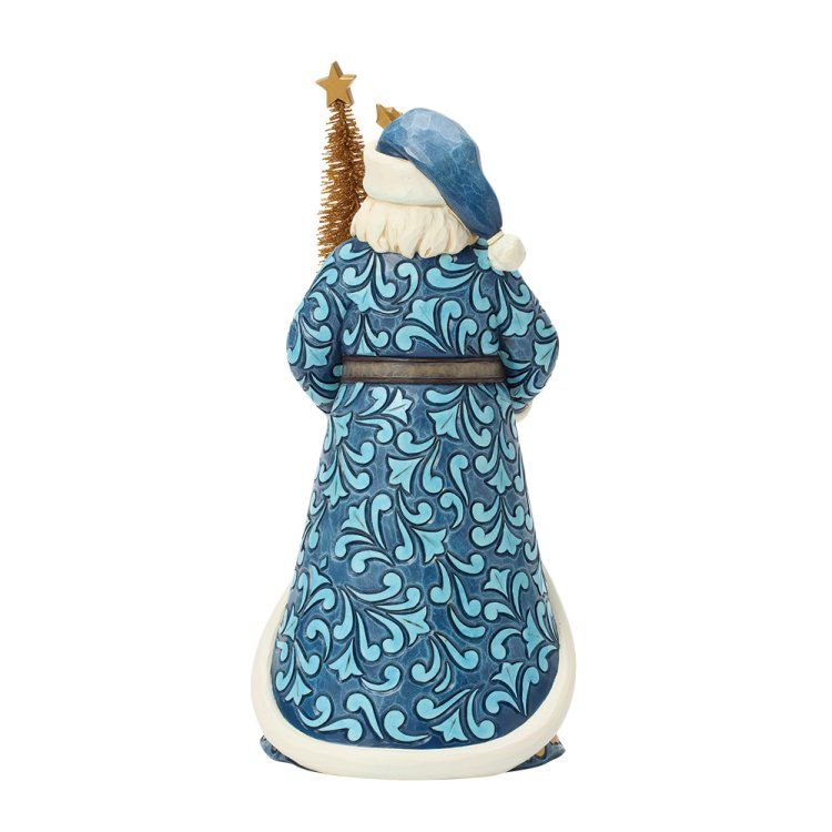 Achteraanzicht van een kerstmanfiguur in een blauw, patroonrijk gewaad, die een klein boompje met een ster vasthoudt.