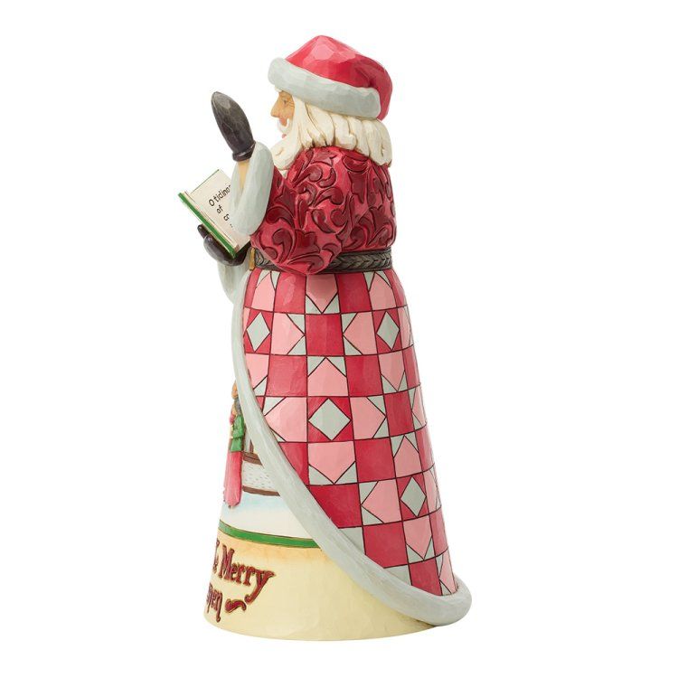 Een kerstmanfiguur met een rood-roze geblokte jas, die een boek vasthoudt.
