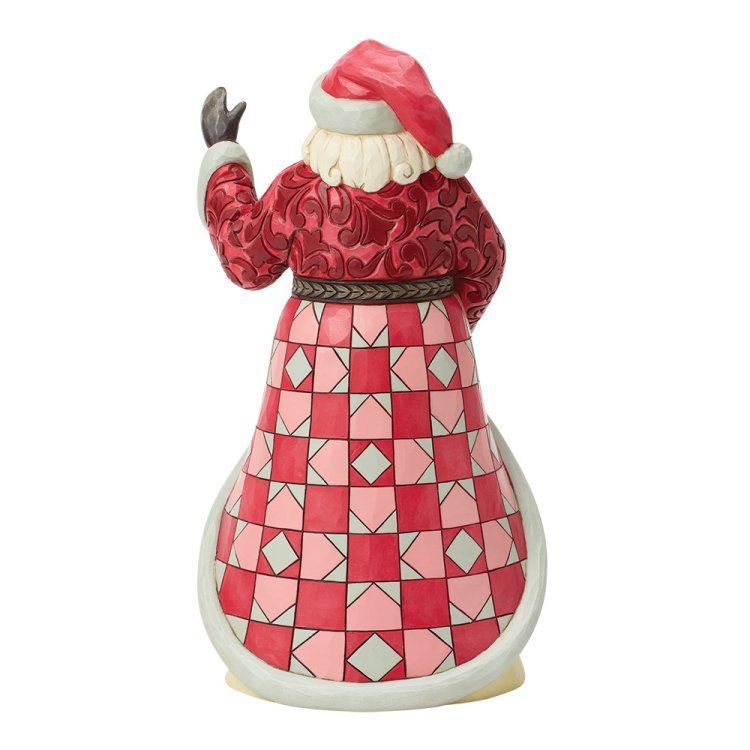 Een kerstmanfiguur met een liedboek in zijn hand, zingend. Een rode jas boven een tafereel van kerstzangers, met op de sokkel de tekst 