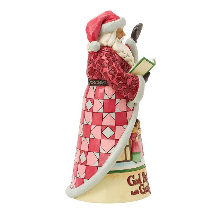 Een kerstmanfiguur in een rode jas met een boek in zijn hand, met een patchworkontwerp. Op de voet staat de tekst 