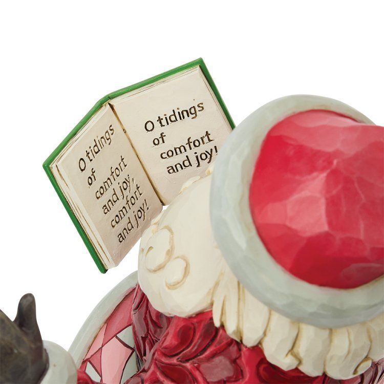 Een kerstmanfiguurtje dat een groen boek openhoudt bij 