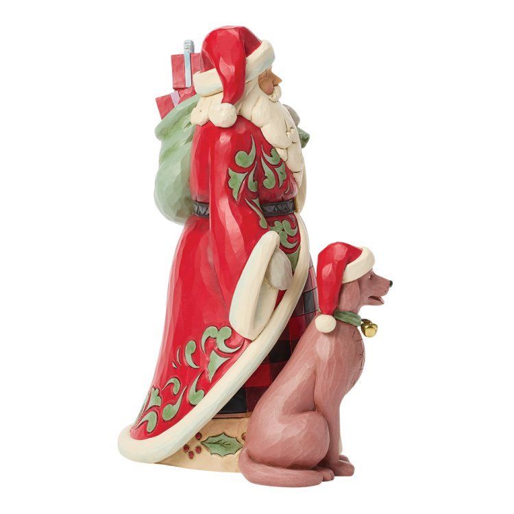 Standbeeld van de Kerstman met een hond die een kerstmuts draagt; rode en groene details.