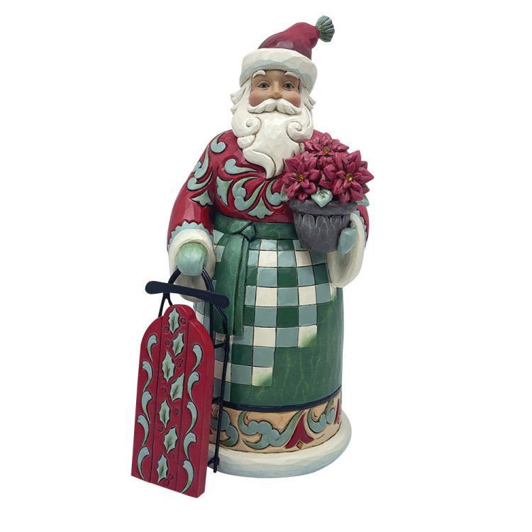 Een kerstmanfiguur met kerststerren en een rode slee; hij draagt ​​een rode jas en een groene schort.