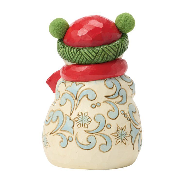 Sneeuwpopfiguurtje met rode muts en sjaal, blauw patroon op het lijfje en groene hoedband.