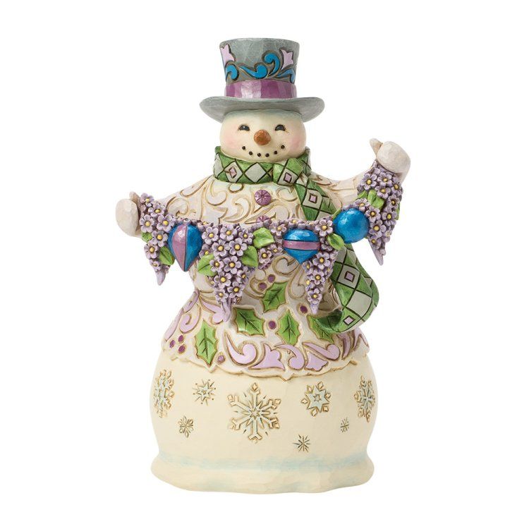 Een lachende sneeuwpop met een hoge hoed op, die een slinger van versieringen en bloemen vasthoudt.