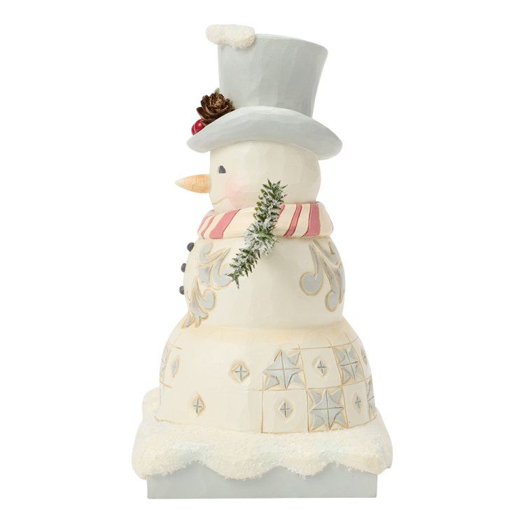Sneeuwpopfiguurtje met hoge hoed, sjaal en takjes. Het staat op een besneeuwde ondergrond.