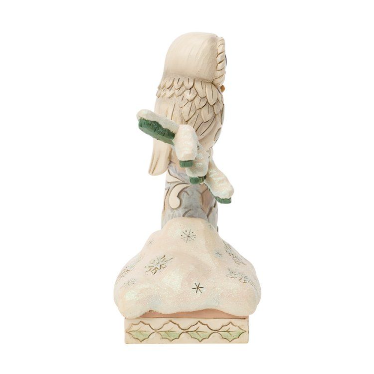 Een decoratief uilenbeeldje, zittend op een met sneeuw bedekte paal; in crèmekleur, groen en beige.