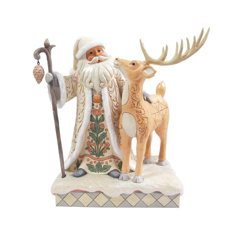De kerstman met een rendierfiguur. De kerstman draagt ​​een crèmekleurig gewaad en heeft een staf in zijn hand; het rendier is lichtbruin.