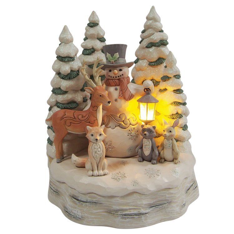 Een kersttafereel in de sneeuw met een sneeuwpop, hert, vos, kat, konijn en met sneeuw bedekte bomen.