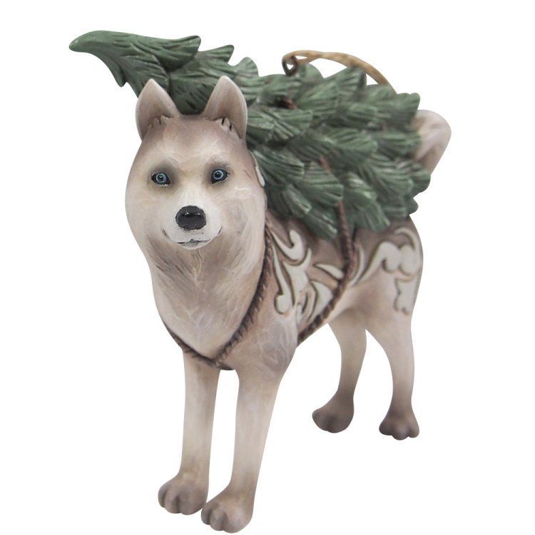 Een beeldje van een hond die een kleine kerstboom op zijn rug draagt. De hond is lichtbruin met groene vacht.