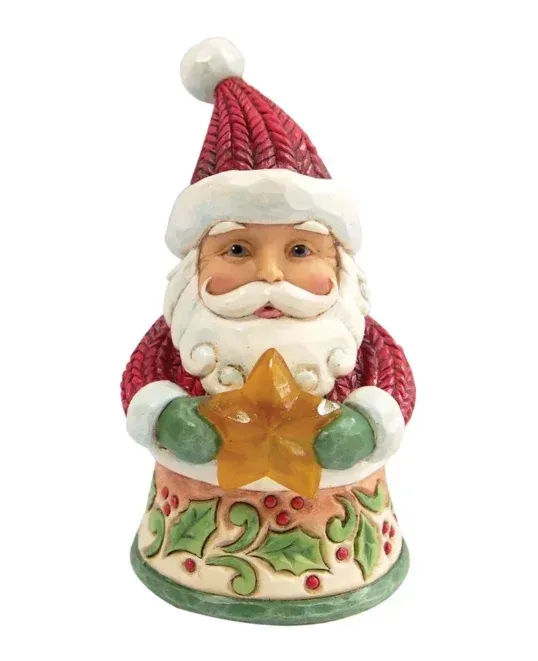 Een kerstmanfiguur met een gouden ster in zijn hand, gekleed in een rode gebreide muts en trui, op een voetstuk versierd met hulsttakken.