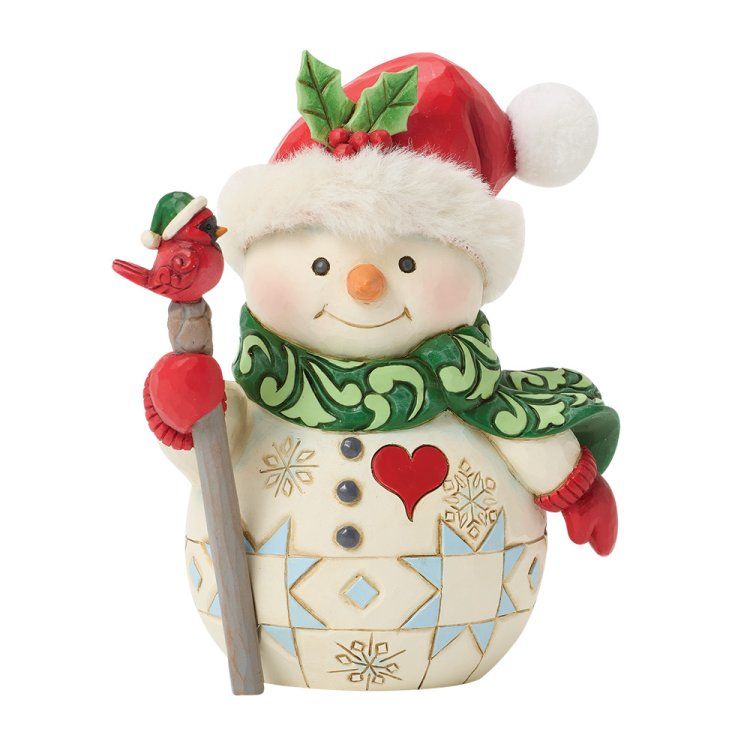 Een sneeuwpopfiguur met een rode muts en een groene sjaal, die een staf met een vogel vasthoudt.
