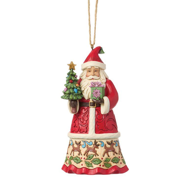 Een kerstmanfiguur houdt een klein boompje en een cadeautje vast, en draagt een rode jas met feestelijke versieringen.