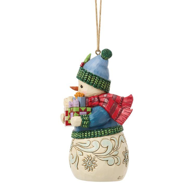 Een sneeuwpopfiguur met cadeautjes, een blauwe muts en een sjaal. Beige lijfje met sneeuwvlokkenmotief.