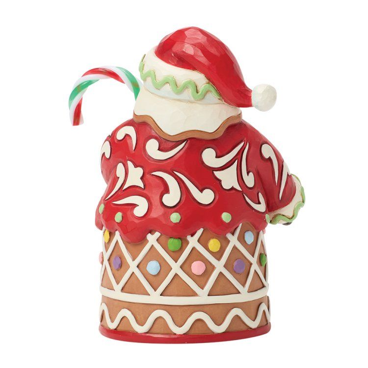 Een kerstmanfiguur met een zuurstok in zijn hand, gekleed in een rode jas versierd als peperkoek.