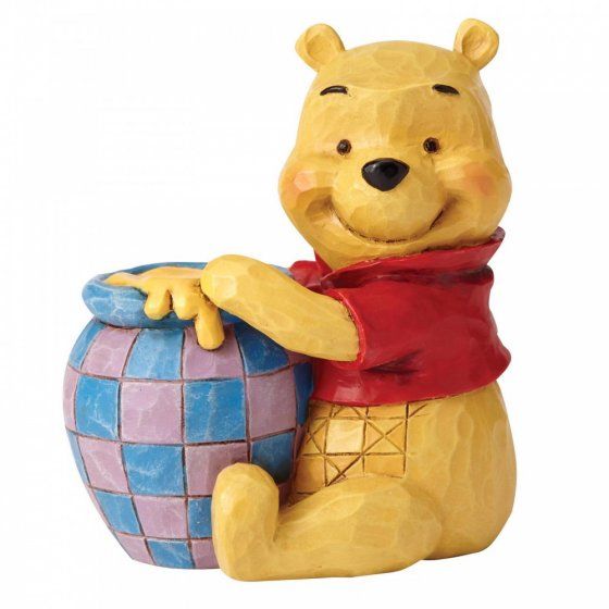 Winnie de Pooh-figuurtje met honingpot, gele beer, rood shirt, zittend en lachend.