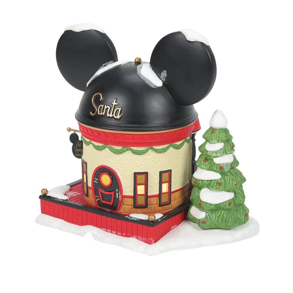 Een kerstwinkel in Disney-thema met Mickey Mouse-oren bovenop, bedekt met sneeuw en met rode en zwarte accenten.