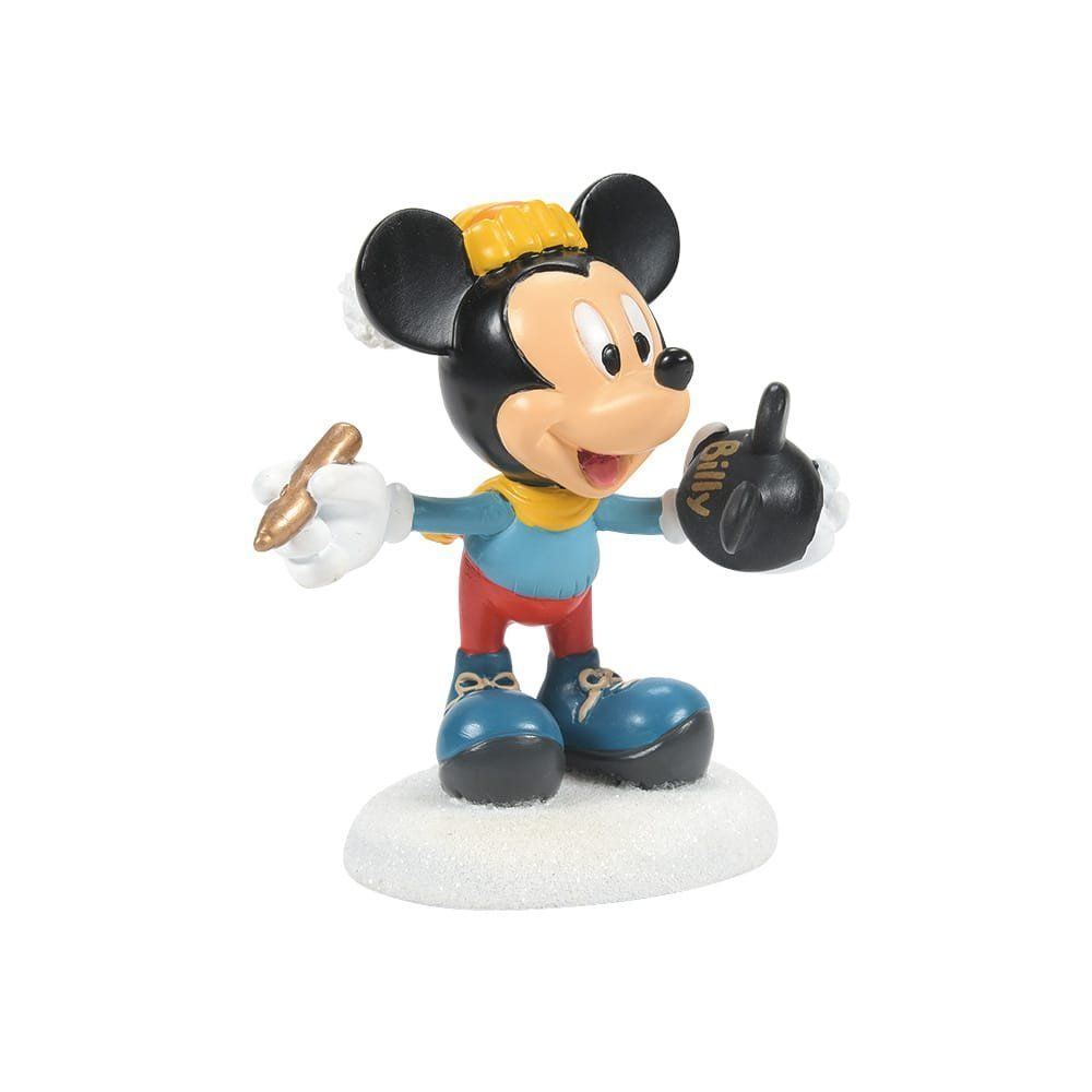 Een Mickey Mouse-figuurtje, gekleed in winterkleding en met een ski in zijn hand. Hij staat op een besneeuwde ondergrond.